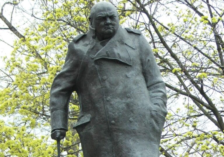 The bronze statue of Winston Churchill in Parliament Square, in his greatcoat with a walking stick