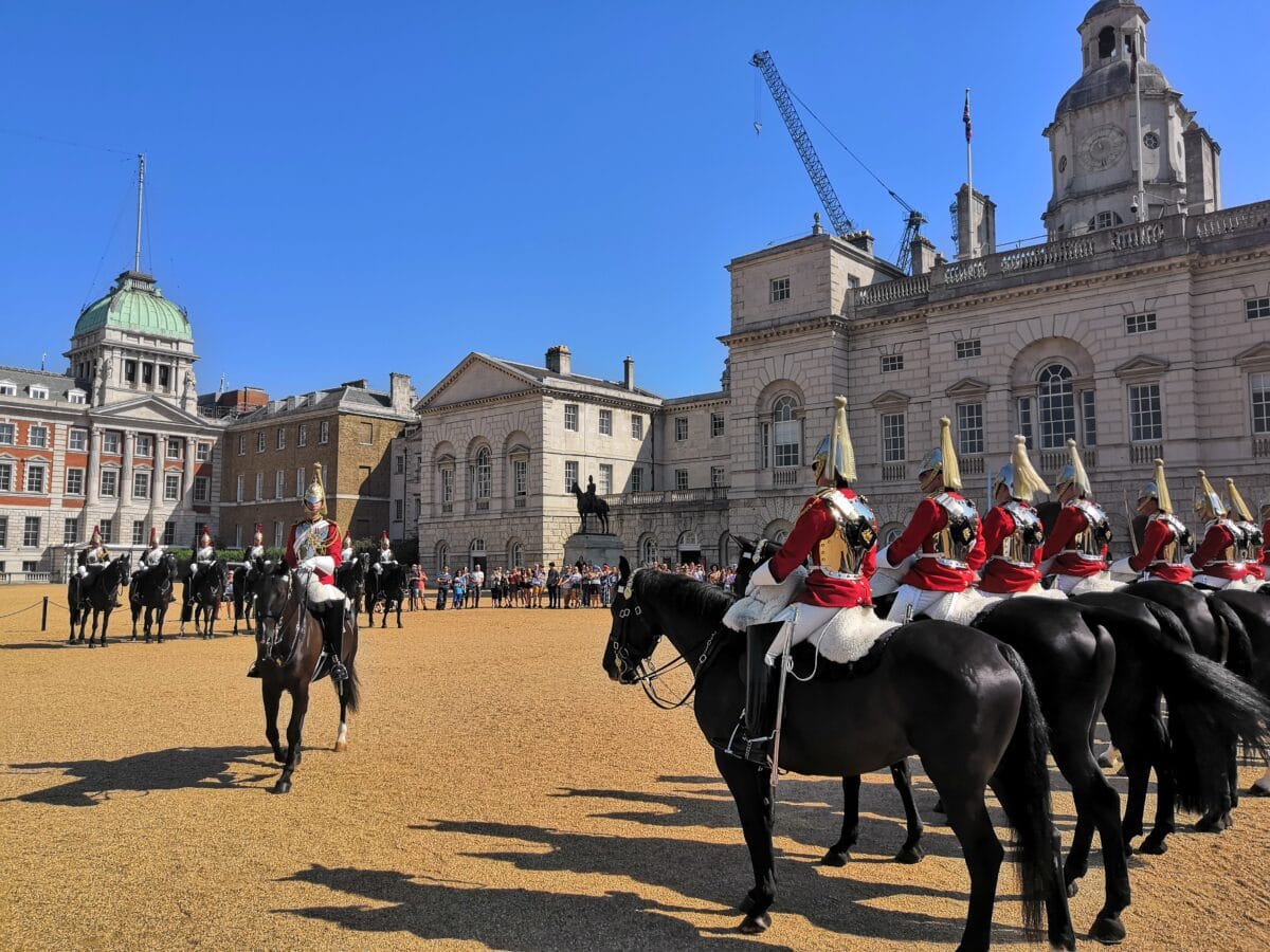 Household Cavalry mounted in plumed helmets and red cloaks on Horse Guards Parade